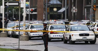 A police officer stands in front of police cars at the Toronto Eaton Centre shopping mall in Toronto, Canada, June 2, 2012. (Reuters File Photo)
