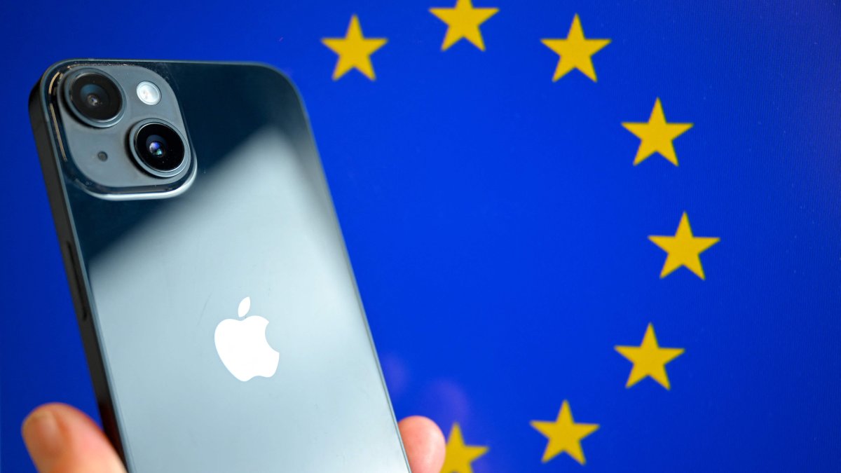 This photograph shows a hand-held smartphone with the Apple company logo and the European Union logo in the background, Brussels, Belgium, Sept. 9, 2024. (AFP Photo)