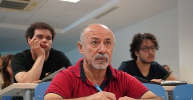 Ismet Güler attends a lecture alongside younger students at Akdeniz University in Antalya, Türkiye, Oct. 10, 2025. (DHA Photo)