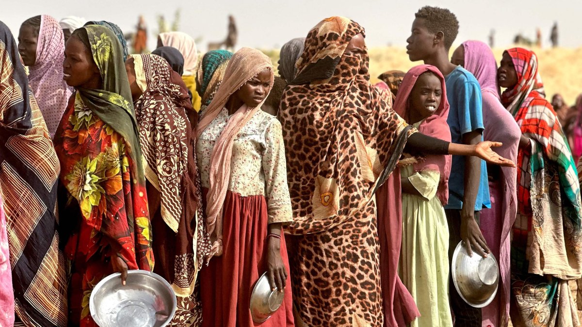 People who fled the Zamzam camp for the internally displaced after it fell under RSF control, queue for food rations in a makeshift encampment in an open field near the town of Tawila in war-torn western Darfur region, Sudan, April 13, 2025. (AFP Photo)
