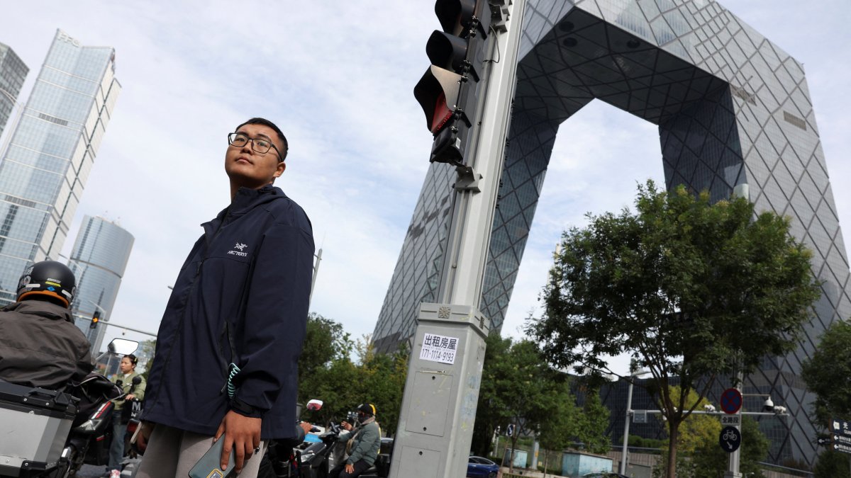 A man waits at an intersection in the central business district (CBD) of Beijing, China, Oct. 11, 2025. (Reuters Photo)
