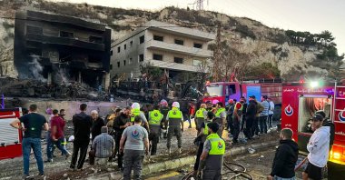 Rescuers and first-responders stand outside a damaged building following an overnight Israeli strike in Al-Msayleh area in southern Lebanon, Oct. 11, 2025. (AFP Photo)