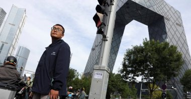 A man waits at an intersection in the central business district (CBD) of Beijing, China, Oct. 11, 2025. (Reuters Photo)