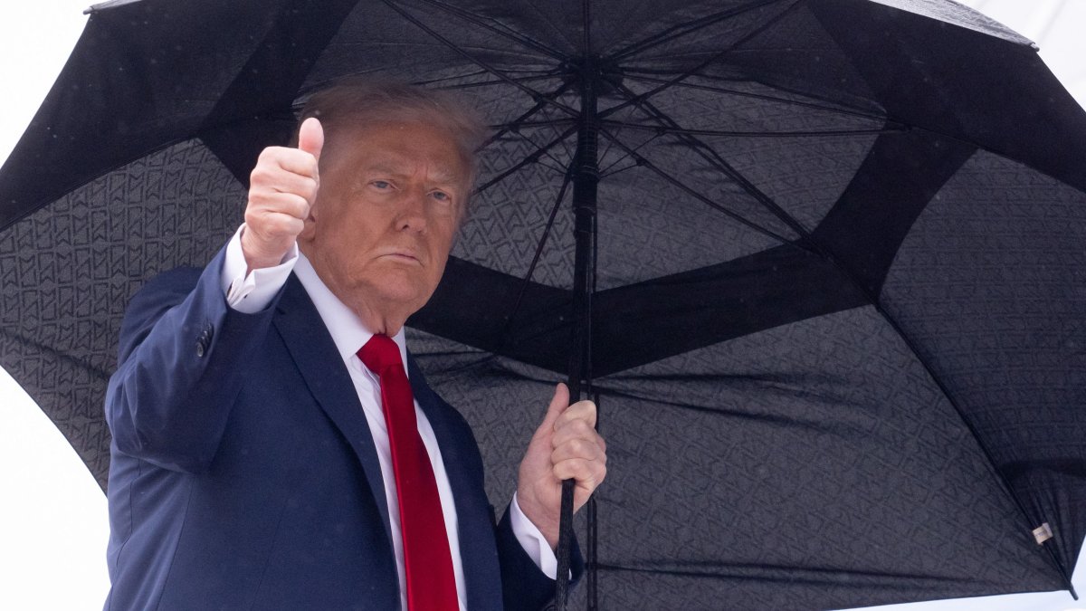 President Donald Trump holds an umbrella as gives a thumbs up while boarding Air Force One prior to departure from Joint Base Andrews in Maryland, U.S., Oct. 12, 2025. (AFP Photo)