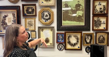 Lindsay Evans gestures to a historic photo of Victorian-era women weaving human hair into art, during a tour of Leila’s Hair Museum in Independence, Miss., U.S., Oct. 6, 2025. (AP Photo)