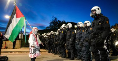 A pro-Palestinian protester faces off with police outside Ullevaal Stadium in Oslo, Norway, Oct. 11, 2025. (AP Photo)