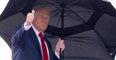 President Donald Trump holds an umbrella as gives a thumbs up while boarding Air Force One prior to departure from Joint Base Andrews in Maryland, U.S., Oct. 12, 2025. (AFP Photo)