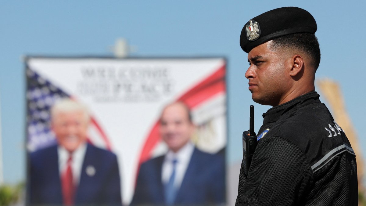 A police officer stands near a poster of the U.S. and Egyptian presidents at Peace Square, ahead of an international summit on Gaza, held amid a cease-fire between Israel and Hamas, Sharm el-Sheikh, Egypt, Oct.13, 2025. (Reuters Photo)