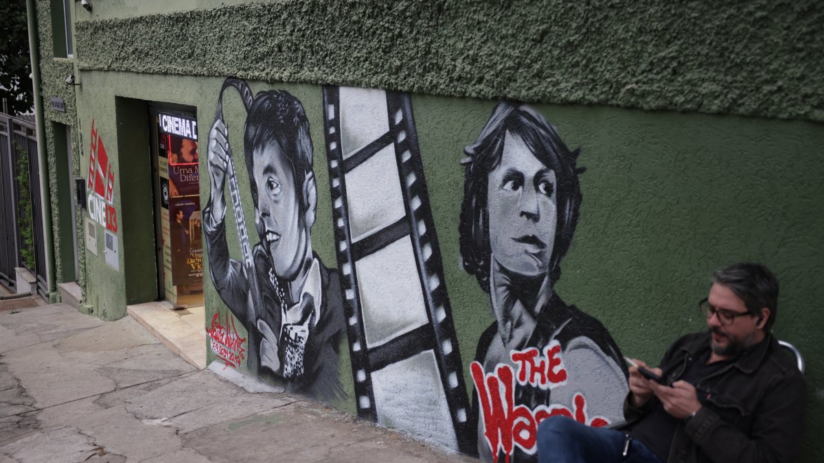 A man sits outside Cine LT3 cinema, built in an old parking garage, Sao Paulo, Brazil, Oct. 9, 2025. (AP Photo)
