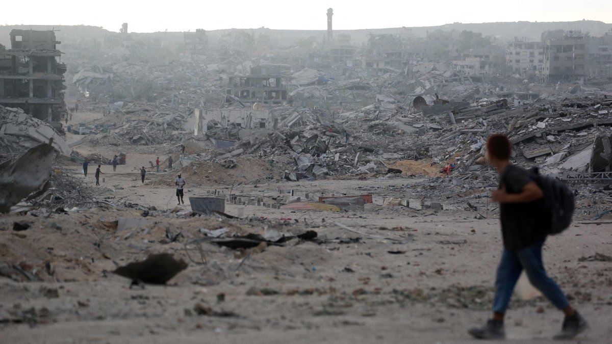 Palestinians make their way past destroyed buildings in Gaza City, Oct. 12, 2025. (AFP Photo)
