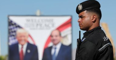 A police officer stands near a poster of the U.S. and Egyptian presidents at Peace Square, ahead of an international summit on Gaza, held amid a cease-fire between Israel and Hamas, Sharm el-Sheikh, Egypt, Oct.13, 2025. (Reuters Photo)