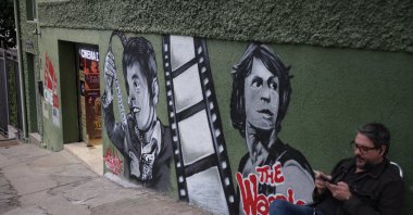 A man sits outside Cine LT3 cinema, built in an old parking garage, Sao Paulo, Brazil, Oct. 9, 2025. (AP Photo)