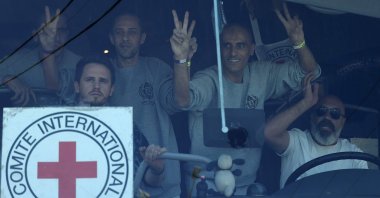 Palestinian men gesture from inside a bus after being released from the Ofer military prison located between Ramallah and Beitunia in the occupied West Bank, Palestine, Oct. 13, 2025. (AFP Photo)