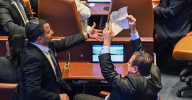 Israeli Knesset member Ayman Odeh (R) holds a sign reading &quot;Recognise Palestine&quot; during a speech by the U,S, president at the Knesset, west Jerusalem, on Oct. 13, 2025. (AFP Photo)