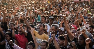 Residents and protesters chant national songs and raise their fists as they gather for a civil society rally demanding the resignation of President Andry Rajoelina and paying tribute to the victims of the protests in Antananarivo, Oct. 13, 2025. (AFP Photo)