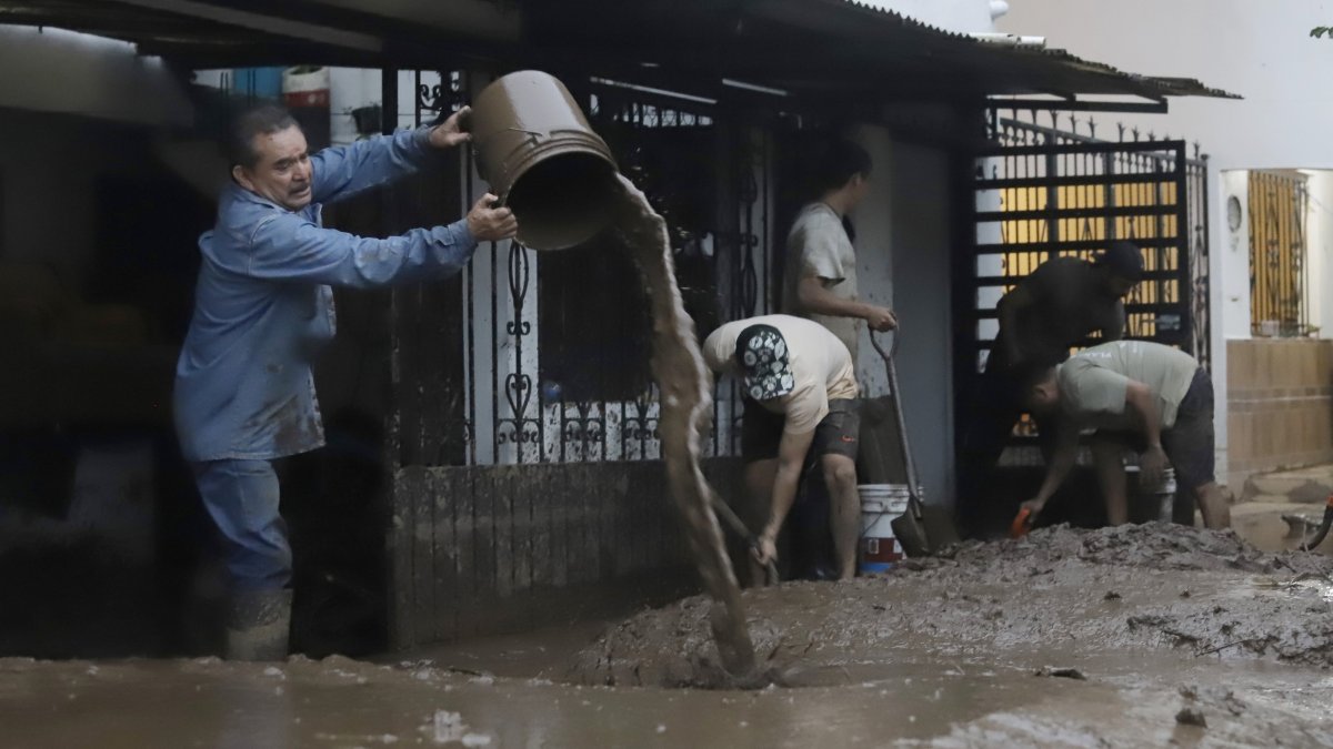 Residents of an area affected by heavy rains remove mud from their homes in Huauchinango, Mexico, Oct. 12, 2025. (EPA Photo)