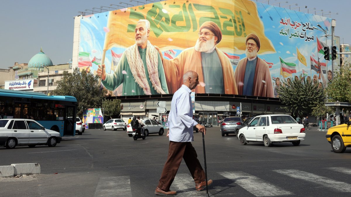 Iranians walk past a billboard depicting Hezbollah&#039;s former leader Hassan Nasrallah (C), Sheikh Safieddin (R), and late Iranian commander Qasem Soleimani (L), in Tehran, Iran, Oct. 13, 2025. (EPA Photo)