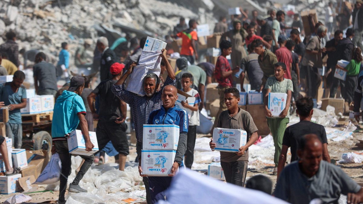 Palestinians receive food parcels after aid trucks entered from the Karem Abu Salem crossing, in Khan Younis, southern Gaza Strip, Palestine, Oct. 12, 2025. (AFP Photo)