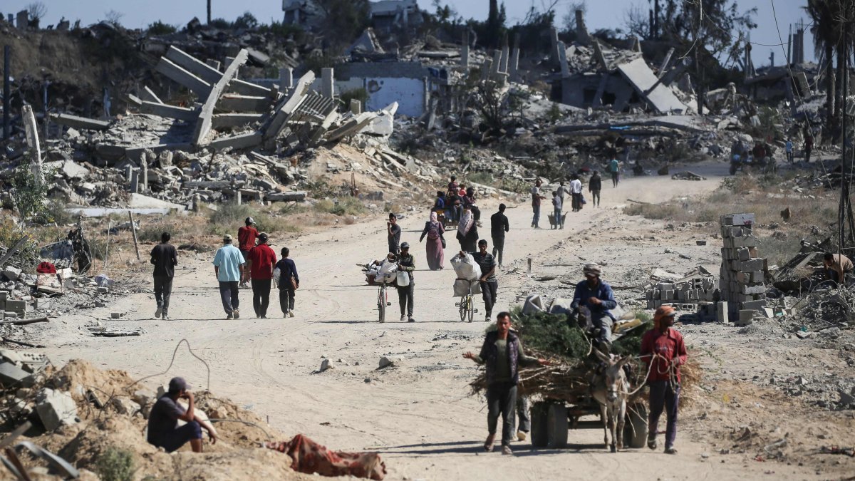 Displaced Palestinians walk past destroyed buildings as they return to their homes in the al-Zahra area, central Gaza Strip, Palestine, Oct. 14, 2025. (AFP Photo)