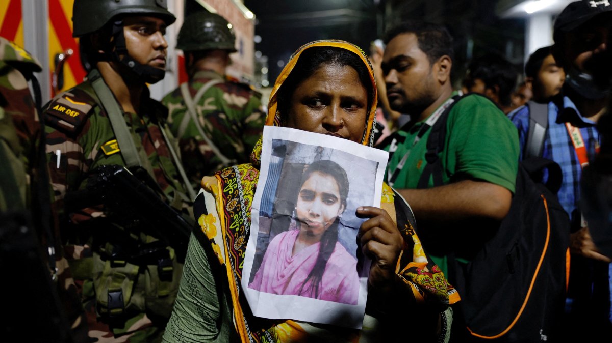 A relative mourns while holding a picture of a missing relative following a fire that broke out at a garment factory and a chemical warehouse in Dhaka, Bangladesh, Oct. 14, 2025. (Reuters Photo)