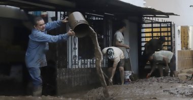 Residents of an area affected by heavy rains remove mud from their homes in Huauchinango, Mexico, Oct. 12, 2025. (EPA Photo)
