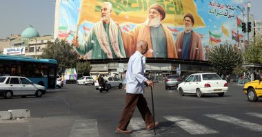 Iranians walk past a billboard depicting Hezbollah&#039;s former leader Hassan Nasrallah (C), Sheikh Safieddin (R), and late Iranian commander Qasem Soleimani (L), in Tehran, Iran, Oct. 13, 2025. (EPA Photo)