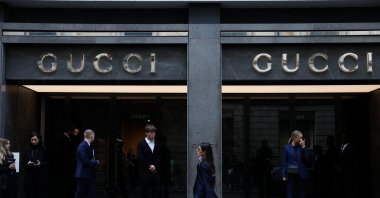 A woman walks past a Gucci store in Milan, Italy, Sept. 24, 2025. (Reuters Photo)