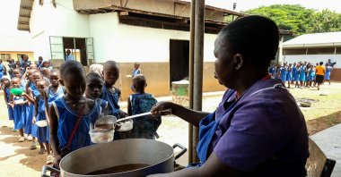 Pupils are served food during lunch time at Kangole Girls Primary School, Napaka, Karamoja region, Uganda, July 21, 2025. (Getty Images Photo)