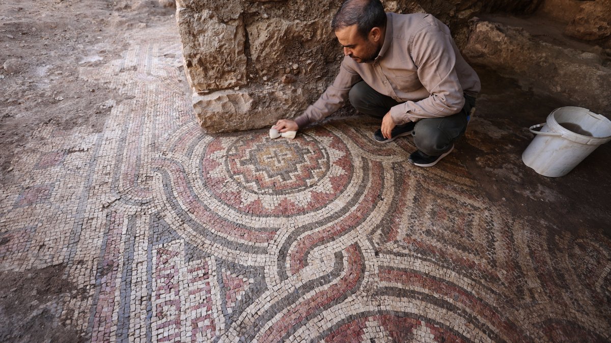 An expert works on the mosaic discovered during cleaning at a historic mill in the Midyat district of Mardin, southeastern Türkiye, Oct. 9, 2025. (AA Photo)