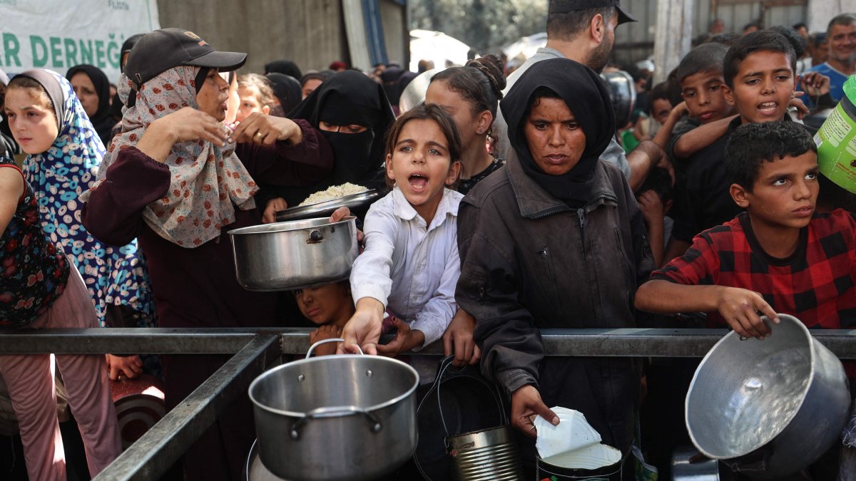 Palestinians gather to receive food portions from a charity kitchen in the Nuseirat refugee camp, located in the central Gaza Strip, Palestine, Oct. 15, 2025. (AFP Photo)