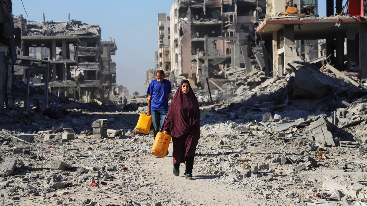 Palestinians walk past the rubble of destroyed buildings, amid a ceasefire between Israel and Hamas, in Gaza City, October 15, 2025. REUTERS/Ebrahim Hajjaj     TPX IMAGES OF THE DAY     