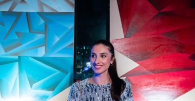 Turkish artist Dilek Yalçın poses in front of pieces from her “I Declare Peace” exhibition in Miami, U.S, in this undated photo. (Courtesy of Dilek Yalçın)