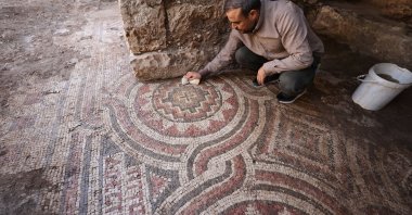 An expert works on the mosaic discovered during cleaning at a historic mill in the Midyat district of Mardin, southeastern Türkiye, Oct. 9, 2025. (AA Photo)