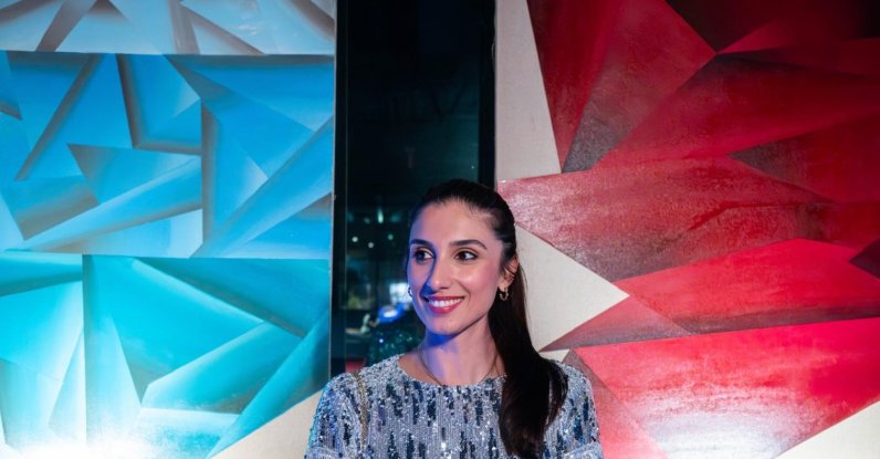 Turkish artist Dilek Yalçın poses in front of pieces from her “I Declare Peace” exhibition in Miami, U.S, in this undated photo. (Courtesy of Dilek Yalçın)