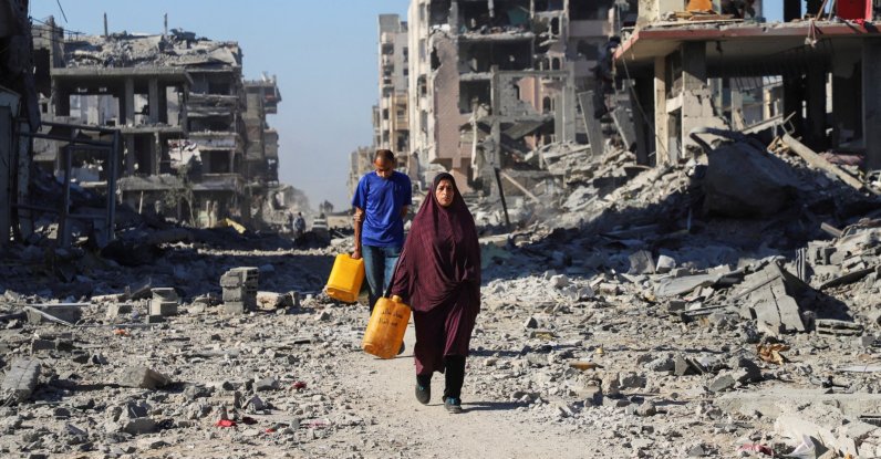 Palestinians walk past the rubble of destroyed buildings, amid a ceasefire between Israel and Hamas, in Gaza City, October 15, 2025. REUTERS/Ebrahim Hajjaj     TPX IMAGES OF THE DAY     