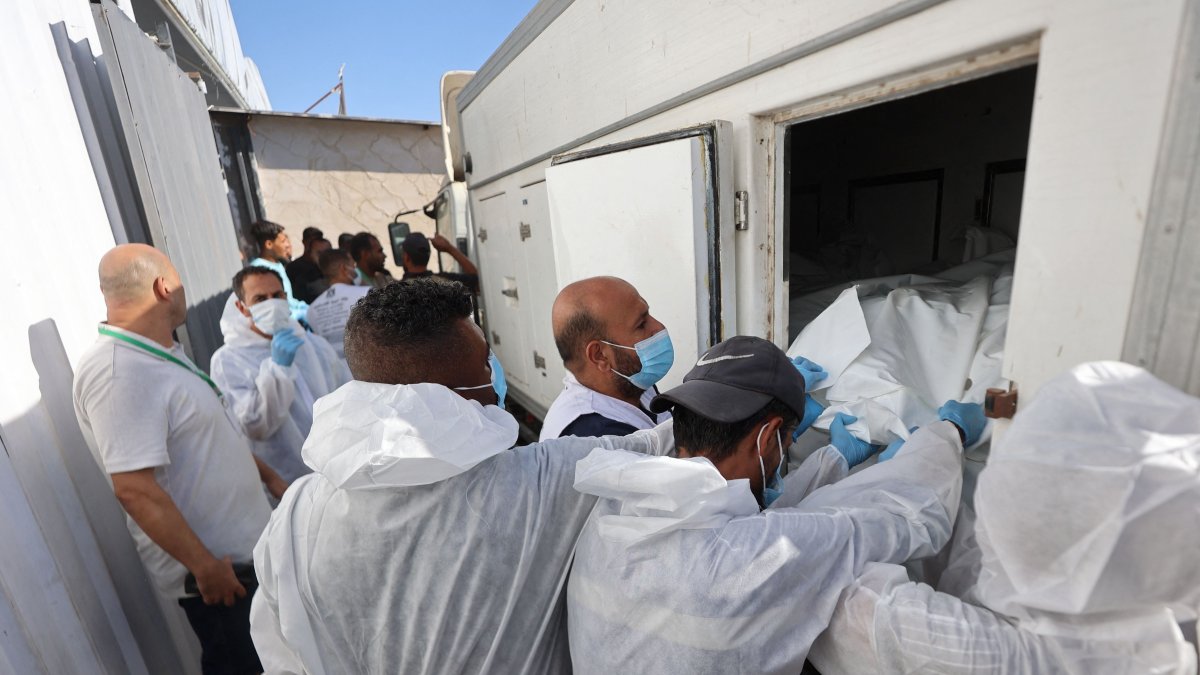 Morgue workers unload the bodies of Palestinians that had been in Israeli custody, after they were transported by Red Crescent vehicles and refrigerated trucks, to the Nasser hospital in Khan Younis, Gaza Strip, Palestine, Oct. 15, 2025. (AFP Photo)
