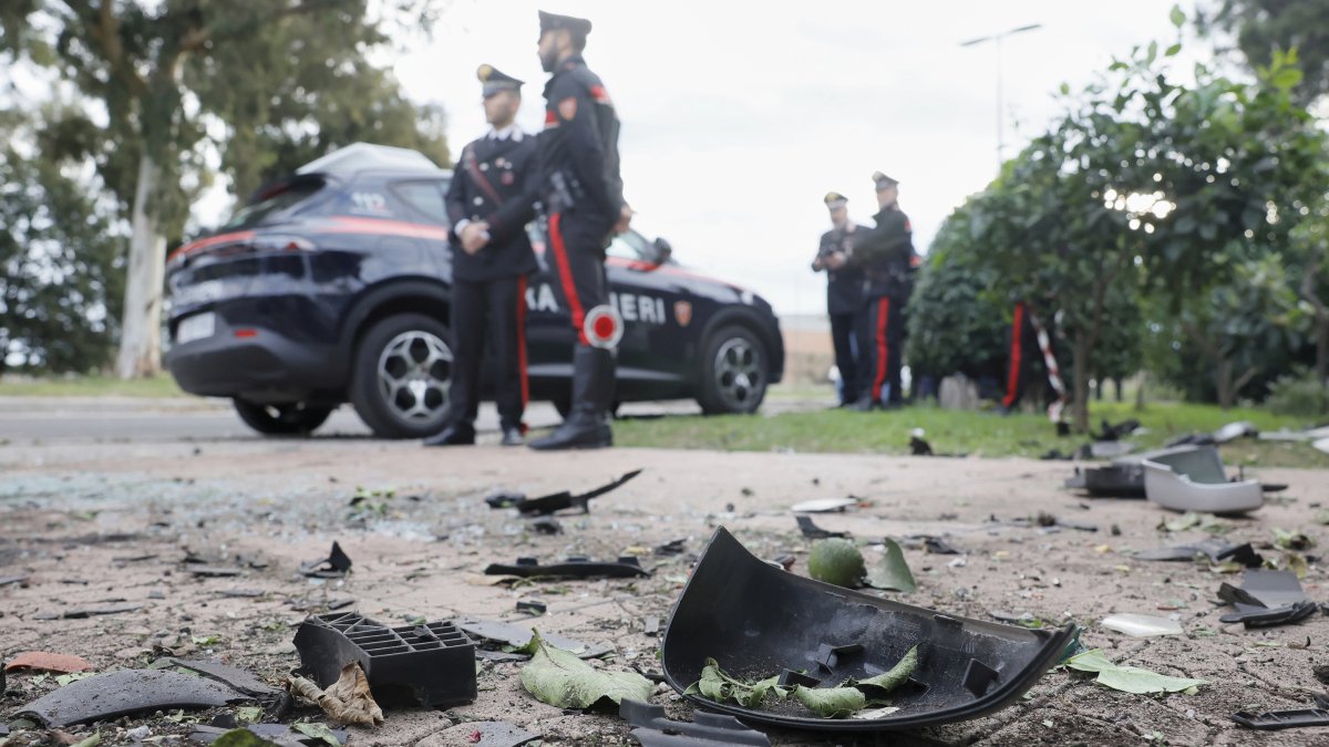 Parts of a car are seen on the ground as Carabinieri military police stand outside the home of investigative journalist Sigfrido Ranucci after an explosive device detonated under the car, Pomezia, Italy, Oct. 17, 2025. (AP Photo)