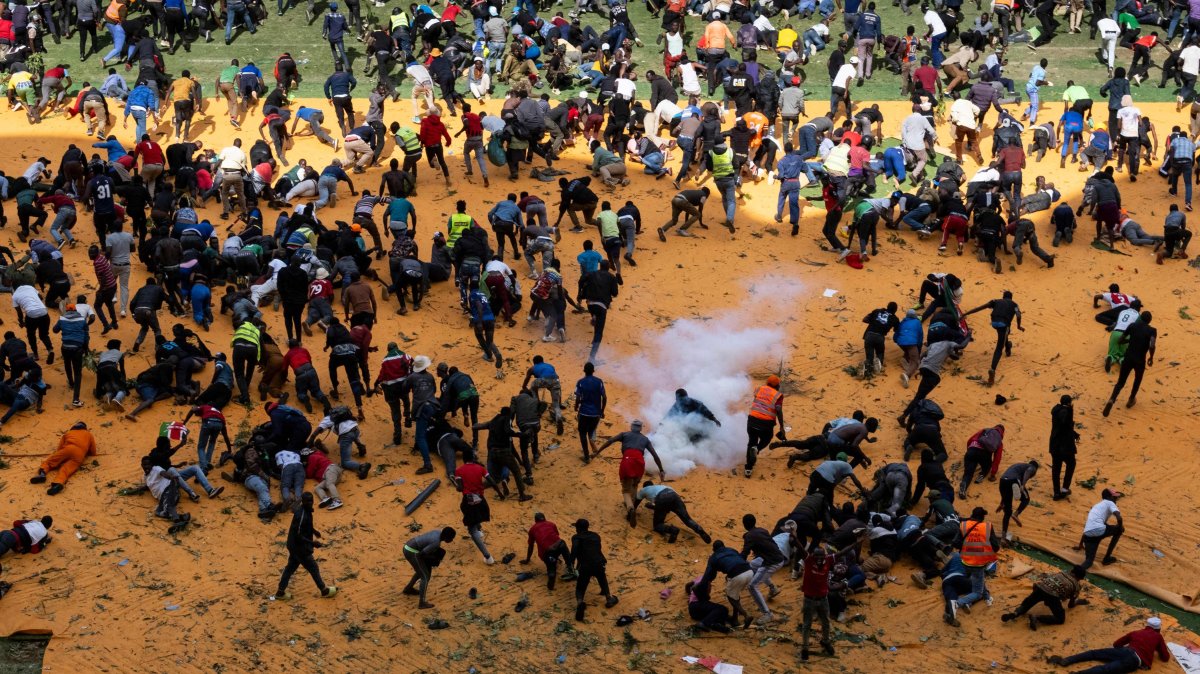 Supporters and mourners of Kenyan opposition leader Raila Odinga run for cover after gunshots and teargas were fired during a gathering for the public viewing of his coffin at the Kasarani Stadium, Nairobi, Kenya, Oct. 16, 2025. (AFP Photo)