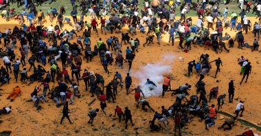 Supporters and mourners of Kenyan opposition leader Raila Odinga run for cover after gunshots and teargas were fired during a gathering for the public viewing of his coffin at the Kasarani Stadium, Nairobi, Kenya, Oct. 16, 2025. (AFP Photo)