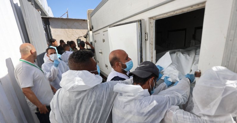 Morgue workers unload the bodies of Palestinians that had been in Israeli custody, after they were transported by Red Crescent vehicles and refrigerated trucks, to the Nasser hospital in Khan Younis, Gaza Strip, Palestine, Oct. 15, 2025. (AFP Photo)