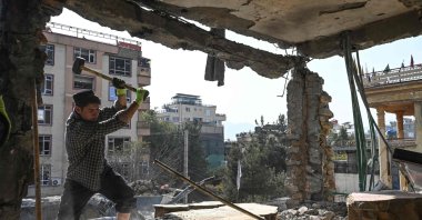 An Afghan man removes debris from a house, which was damaged after an air strike during cross-border clashes between Afghanistan and Pakistan, in Kabul, Afghanistan, Oct. 16, 2025. (AFP Photo)