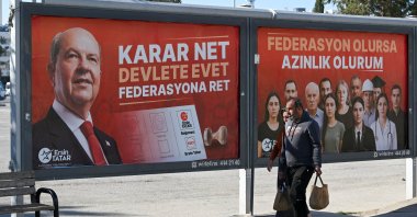 People walk by campaign billboards of incumbent president Ersin Tatar in the capital Lefkoşa (Nicosia), the Turkish Republic of Northern Cyprus (TRNC), Oct. 18, 2025. (AA Photo)