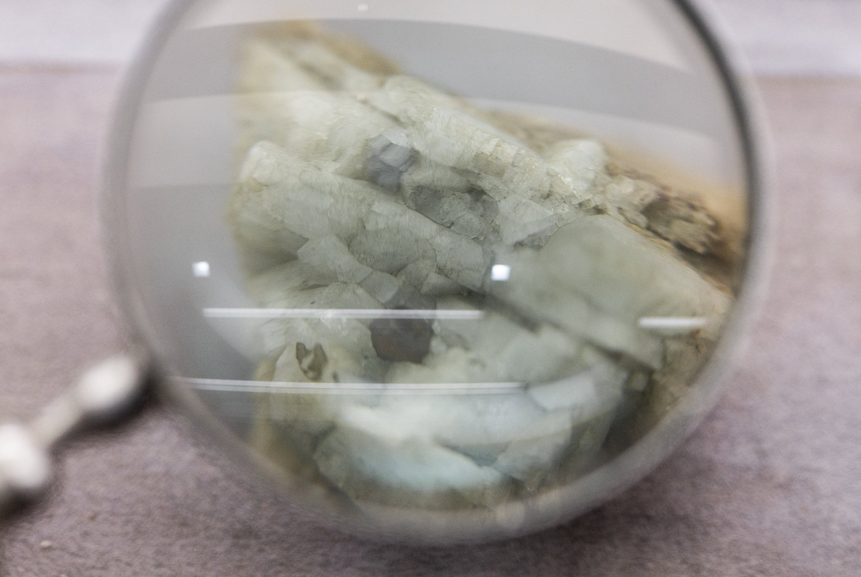 A sample of monazite, a mineral used in the rare earth industry to extract elements such as cerium, lanthanum, and neodymium, is displayed next to a magnification glass at the Geological Museum of China, Beijing, China, Oct. 14, 2025. (Reuters Photo)