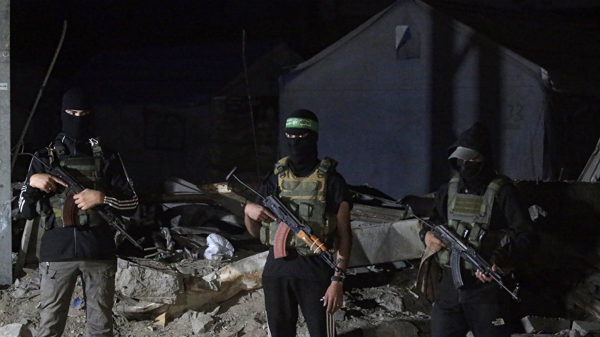 Palestinian fighters from Hamas&#039;s Izz ad-Din al-Qassam Brigades guards as vehicles of the International Committee of the Red Cross (ICRC) arrive to transport remains of Israeli hostages handed over by Hamas in Gaza City, Oct. 15, 2025. (EPA Photo)