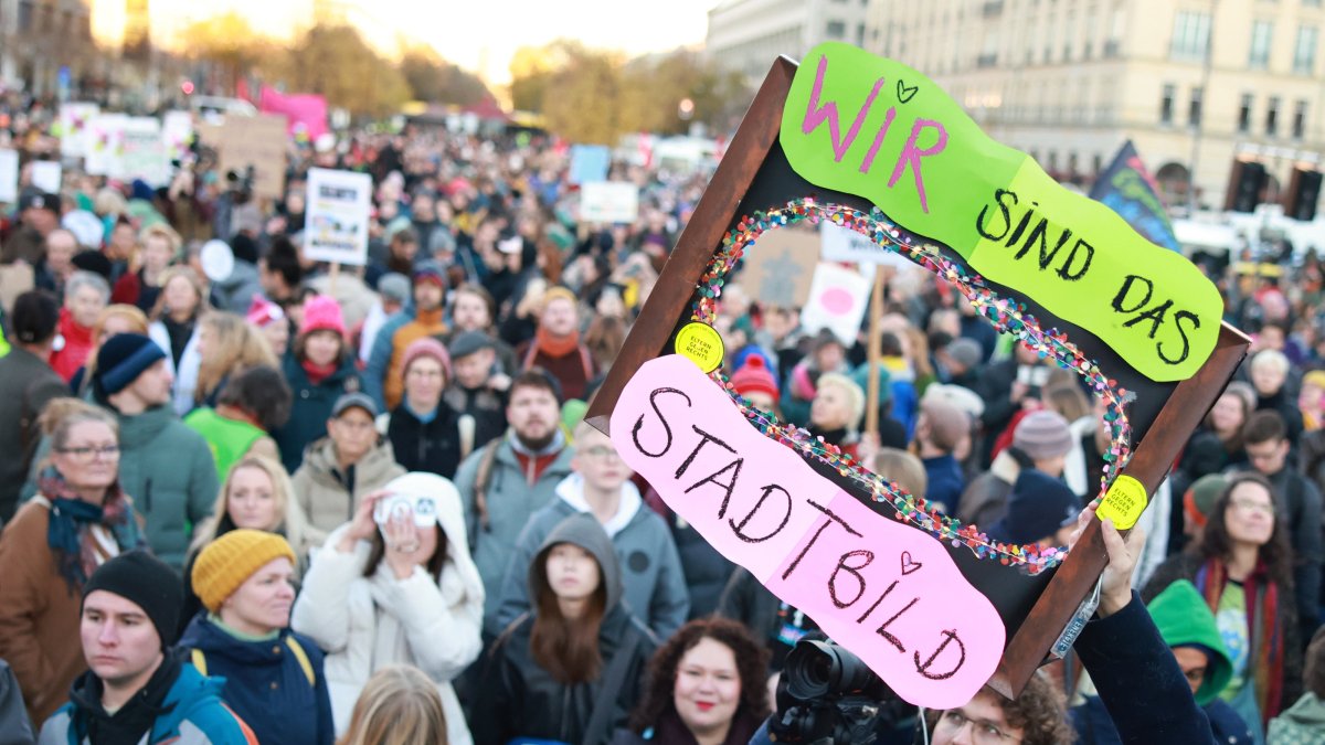 A participant holds a placard that reads ‘Firewall up! We are the Cityscape’ during a rally at the Brandenburg Gate landmark in Berlin, Germany, Oct. 19, 2025. (EPA Photo)