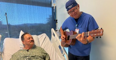 Nurse Rod Salaysay plays guitar for patient Richard Hoang in the recovery unit of UC San Diego Health in San Diego, Calif., U.S., Sept. 30, 2025. (AP Photo)