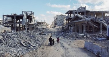 A drone view shows people walking through a destroyed residential neighborhood, Gaza, Palestine, Oct. 18, 2025. (Reuters Photo)