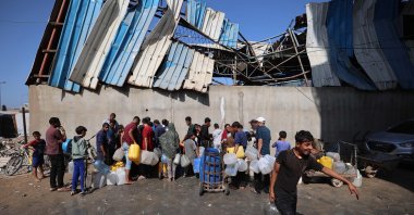 Palestinians fill their containers with fresh water from a public tap in the Nuseirat refugee camp in central Gaza, Palestine, Oct. 19, 2025. (AFP Photo)