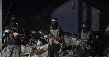 Palestinian fighters from Hamas's Izz ad-Din al-Qassam Brigades guards as vehicles of the International Committee of the Red Cross (ICRC) arrive to transport remains of Israeli hostages handed over by Hamas in Gaza City, Oct. 15, 2025. (EPA Photo)