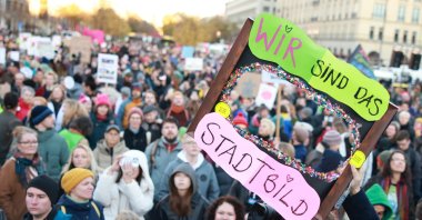 A participant holds a placard that reads ‘Firewall up! We are the Cityscape’ during a rally at the Brandenburg Gate landmark in Berlin, Germany, Oct. 19, 2025. (EPA Photo)